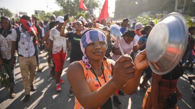 Factory workers demonstrate to demand better wages and working conditions in Port-au-Prince on May 9, 2023. - Employees in the clothing manufacturing sector took part in a demonstration to demand a minimum of 2,500 gourdes ($16) a day. (Photo by Richard PIERRIN / AFP)